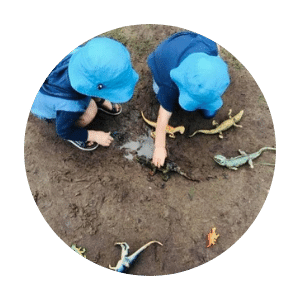 children-playing-in-the-mud-with-dinosaur-toys