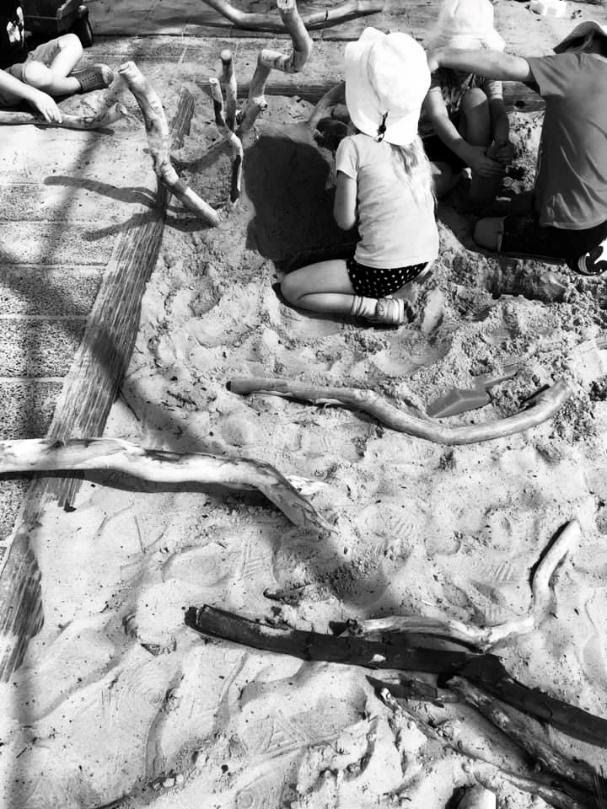 children-playing-in-a-sandpit-with branches